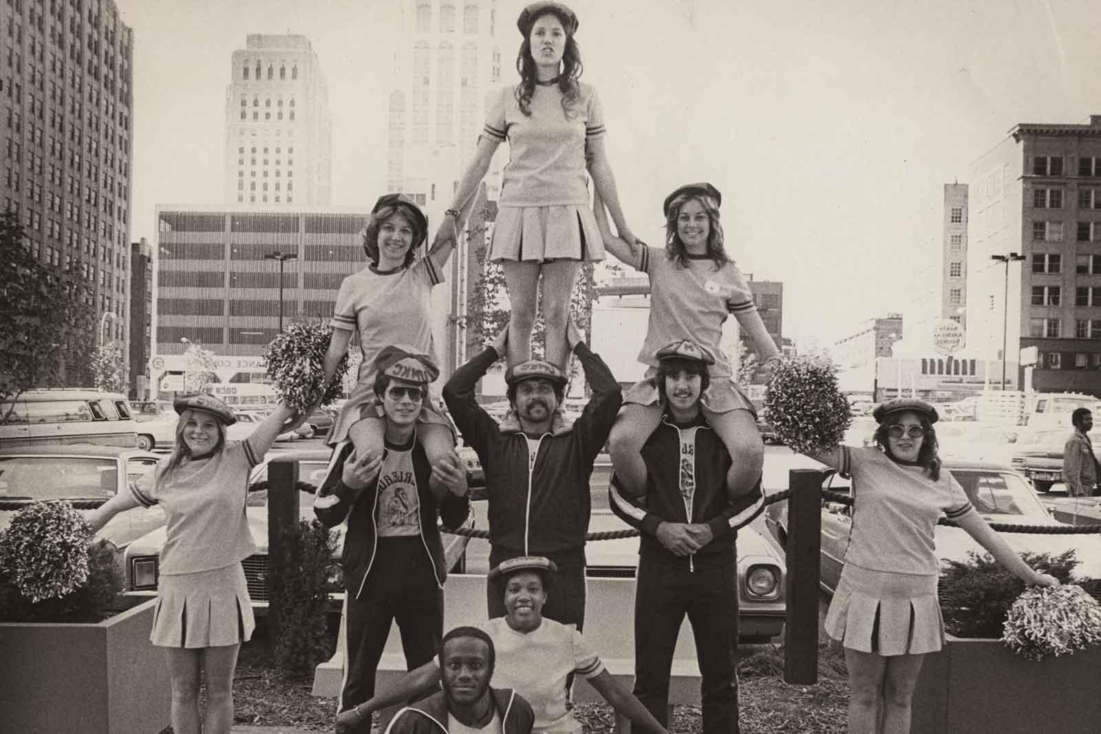 UMKC cheerleaders in black and white picture stand in a pyramid